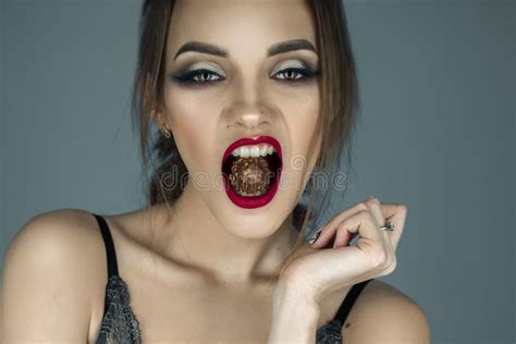 Young Girl With Red Lips Eats Chocolate Candy And Looking At The Stock