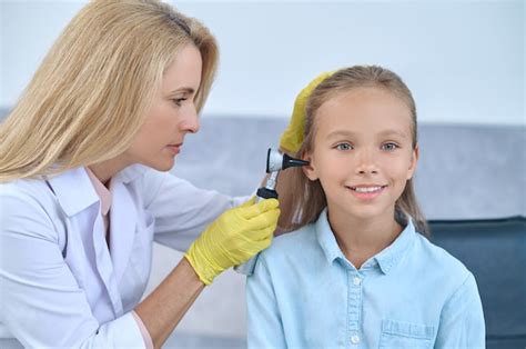 Premium Photo Female Doctor Examining Patient Ear With Otoscope