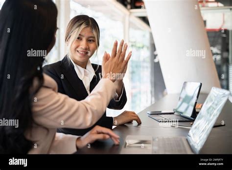 Asian Businesswoman And Her Partners Give Each Other High Fives As They