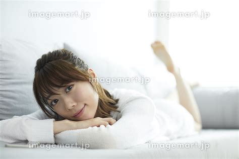 ソファに寝転ぶ日本人女性 129491749 イメージマート