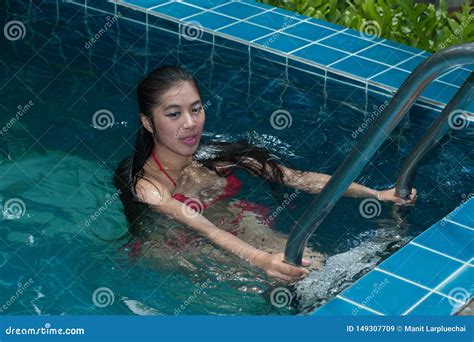 Pretty Asian Woman Wearing Red Bikini Swim And Standing At Stair At Swimming Pool Fotografering