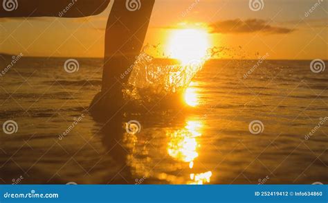 Close Up Carefree Woman Runs Barefoot In Shallow Ocean Water At Golden