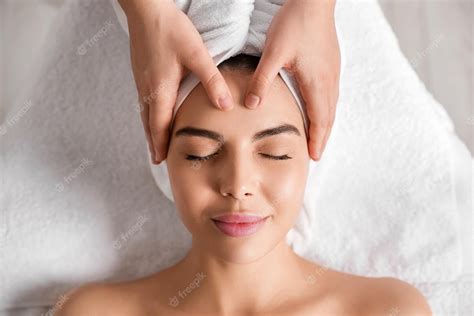 Premium Photo Beautiful Woman Receiving Facial Massage In Beauty Salon Closeup Top View