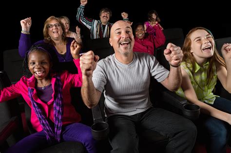 Excited Group Of People Cheering In Movie Theater Stock Photo