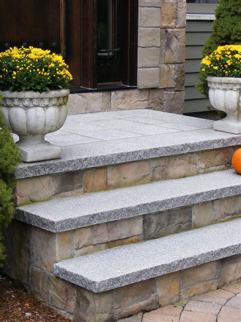 An Orange Pumpkin Sitting On The Steps Of A Stone House With Two