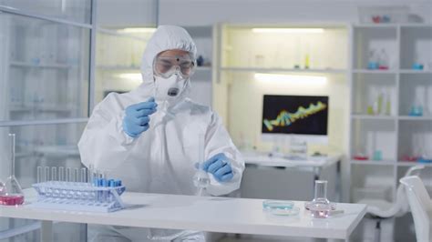 Tracking Shot Of Male Medical Scientist Or Chemist In Full Protective