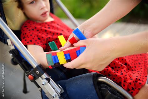 Mother Puts Orthosis On Her Daughter Arms Disabled Girl Sitting On A