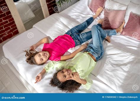 Two Pretty Girls Laying On The Bed And Resting Stock Photo Image Of