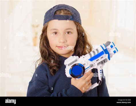 Happy Little Girl Holding A Gun In Her Hands And Wearing Boy Clothes