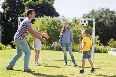 Familia Feliz Jugando Al Fútbol En El Parque Foto Premium
