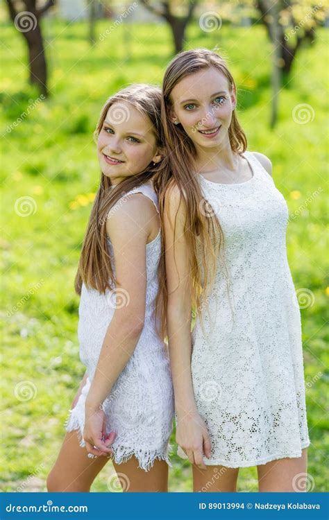 Deux Belles Jeunes Filles Dans Des Robes Blanches En T Photo Stock Image Du Treindre