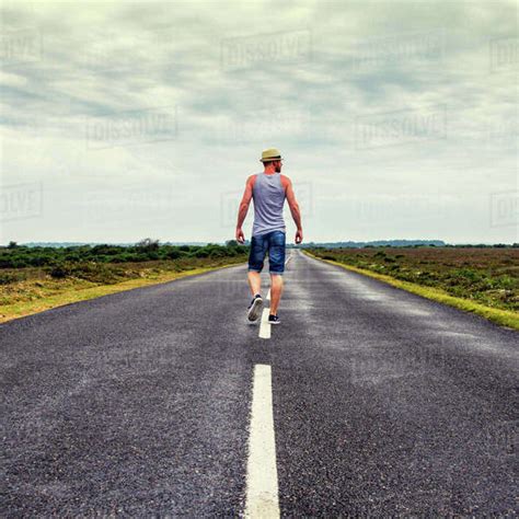 Man Walking Down The Long Road Stock Photo Dissolve