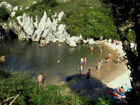 playa de gulpiyuri a sandy beach in the middle of a meadow the adventourist cool travel