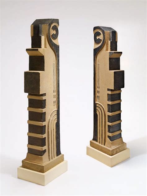 Two Sculptures Made Out Of Wood And Metal On Display In Front Of A