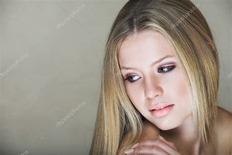 Молодая красивая девочка подросток с длинными светлыми волосами и голубыми глазами с низким