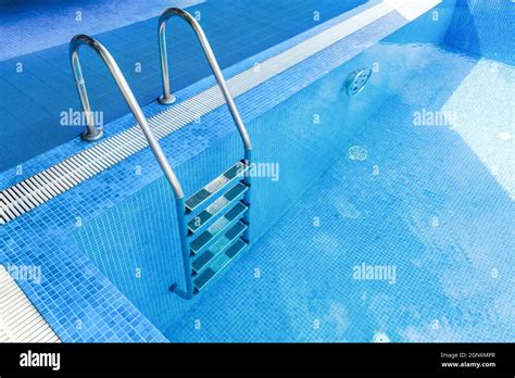 Side Of The Swimming Pool With Steel Staircase And Tiles Stock Photo