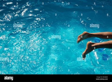 Mans Feet On A Lilo In A Blue Swimming Pool Stock Photo Alamy