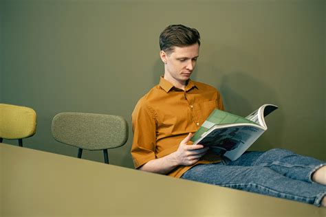 Man Sitting And Reading A Magazine · Free Stock Photo