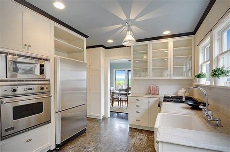 The advantage to cutting crown molding using this method is that no bevel cut is required. white kitchen with a twist....floors! black crown and grey ...
