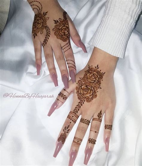 A Woman S Hands With Henna Tattoos On Them And Flowers Painted On The Palms