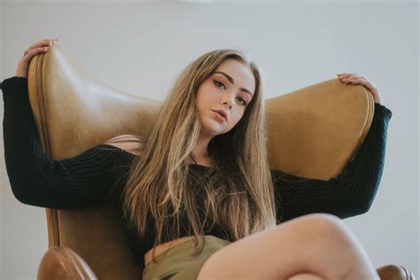 Beautiful Model Sitting On Sofa Looking At Viewer Wallpaper HD Girls