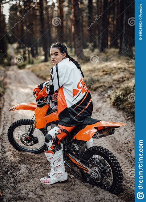 Beautiful Young Female Racer Riding Motocross Bike On A Trail Of Sand