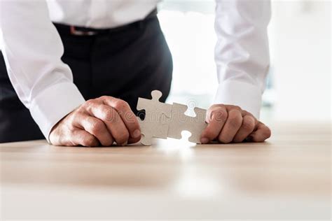 Businessman Connecting Two Matching Puzzle Pieces Stock Photo Image