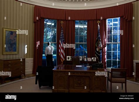 Us President Barack Obama Looks Out The Window Of The Oval Office Of