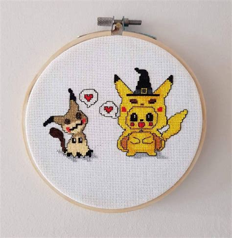 A Cross Stitch Pattern With Two Pikachu And Eevee Characters On It