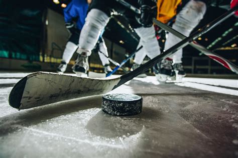 Close Up Of Ice Hockey Puck And Stick During A Match Stock Photo