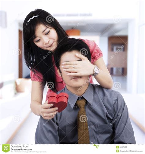 If it's your wife's birthday, you can hide an expensive necklace in a large cereal box. Young Wife Make A Surprise To Husband Stock Photo - Image ...