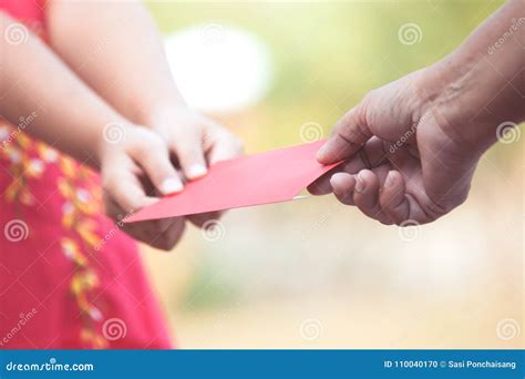 Parent Give Money In Red Envelope To Little Child Girl Stock Photo