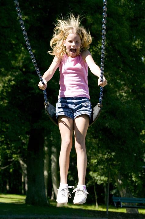Young Girl Playing On A Swing Set At The Park Stock Photo Image Of