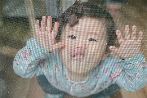 Baby Making Face At Screen Door By Stocksy Contributor Lauren Lee