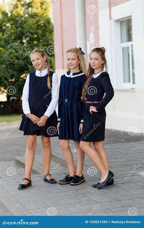 Schoolgirls In School Uniform Rest On A Break Near The School Stock