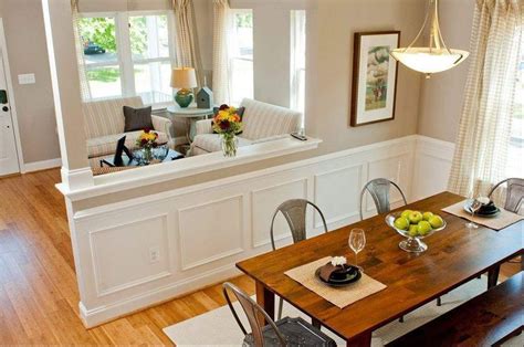 An open concept home decorated with stylish mirrors and various wall arts mounted on the white walls. Half wall | Living room kitchen, Half walls