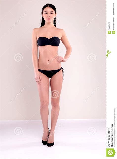 La Bella Donna Con L Ente Perfetto Con Capelli Diritti Scuri Porta Il Bikini Nero Immagine