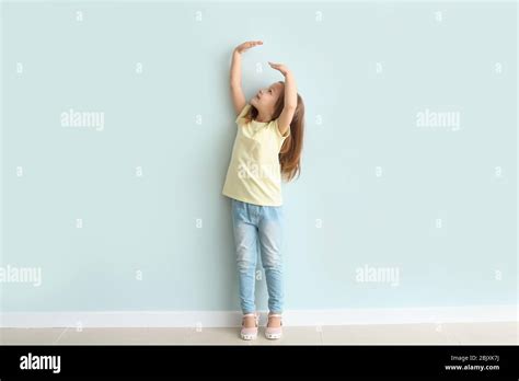 Cute Little Girl Measuring Her Height Near Wall Stock Photo Alamy