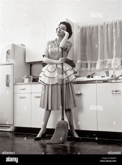1950 Femme Au Foyer Femme Debout Dans La Cuisine Sappuyant Sur Le Balai Photo Stock Alamy