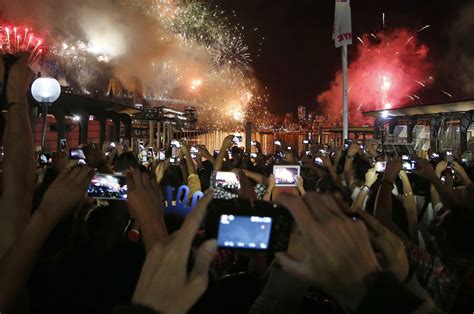 Crowds Watch And Take Photographs As Fireworks Light Up The Sydney