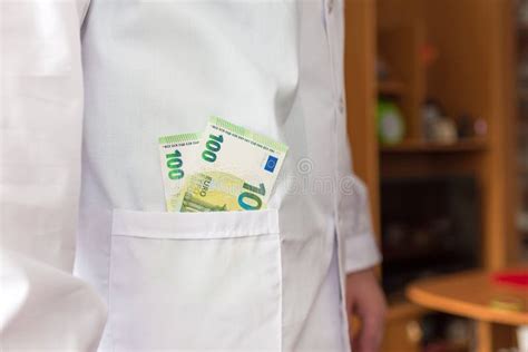 Doctor With Euro Money In The Pocket Wears Medical Uniform Closeup