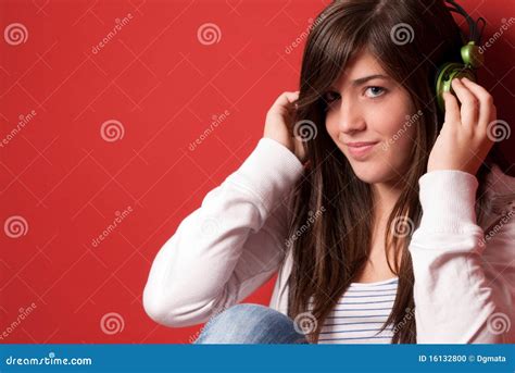 Young Girl Listening Music With Headphones On Red Stock Photo Image