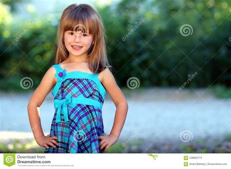 Outdoor Portrait Of Optimistic Smiling Pretty Little Girl