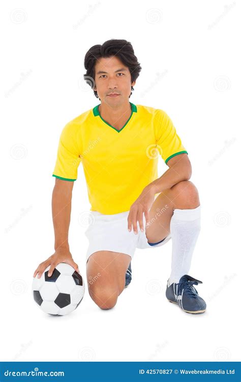 football player in yellow kneeling with ball stock image image of adult sportswear 42570827