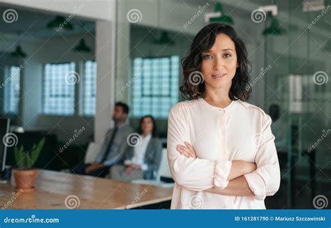 Smiling Young Businesswoman Standing Confidently In A Large Office