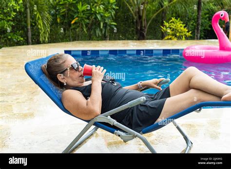 Senior Woman Relaxing In Lounge Chair At Pool Stock Photo Alamy