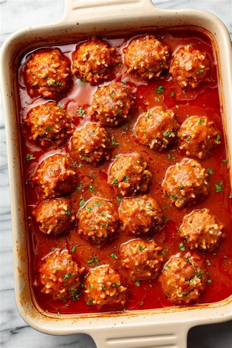 Meatballs Covered In Marinara Sauce In A Casserole Dish On A Marble Surface