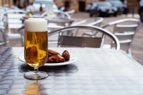 Ice Cold Beers Pouring Into Glasses On Table With Spanish Tapas Stock