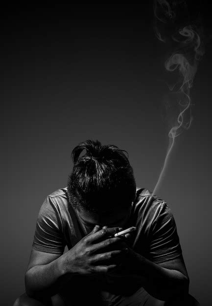 Premium Photo Depressed Man Smoking Cigarette Sitting On Chair On Black