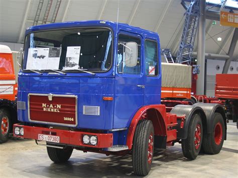 a large blue truck parked inside of a building next to another red and